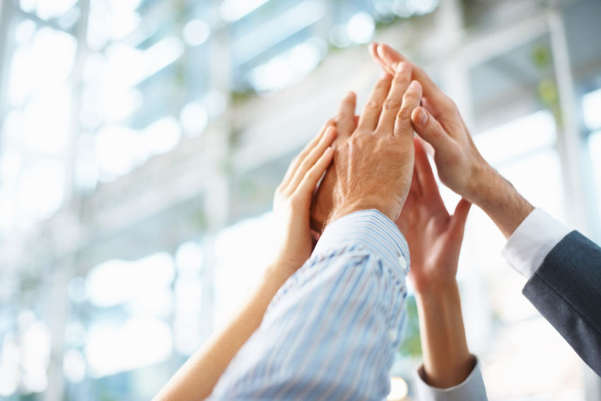 Cropped image of business people hands giving high five